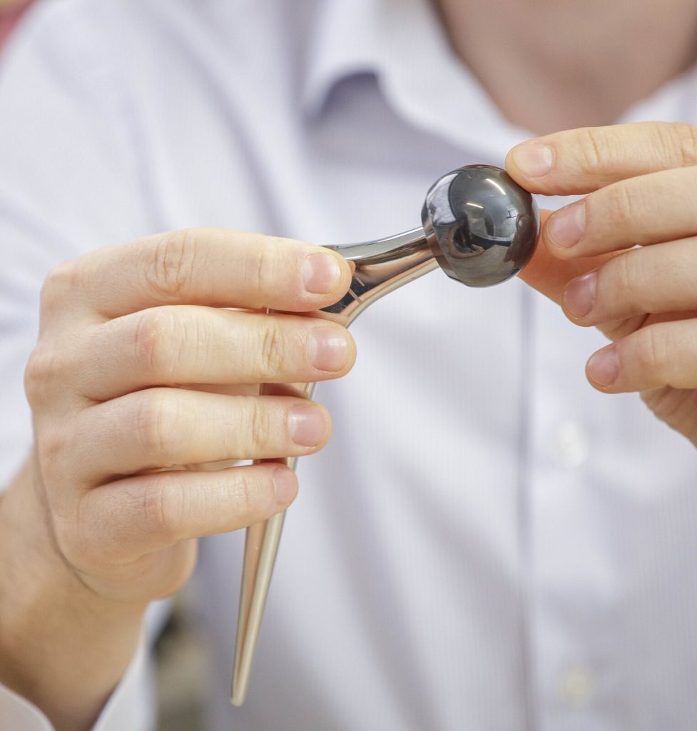 Hip replacement stem and ball held in the hand